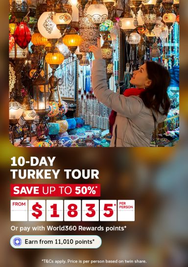 Woman admiring colourful lanterns in a Turkish bazaar for a 10-day Turkey tour saving up to 50% from $1835 per person