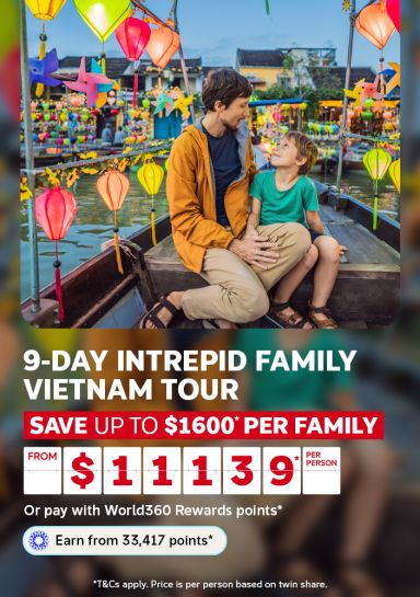 Father and son sharing a moment surrounded by colorful lanterns for a 9-day Intrepid family Vietnam tour saving up to $1600 from $1139 per person