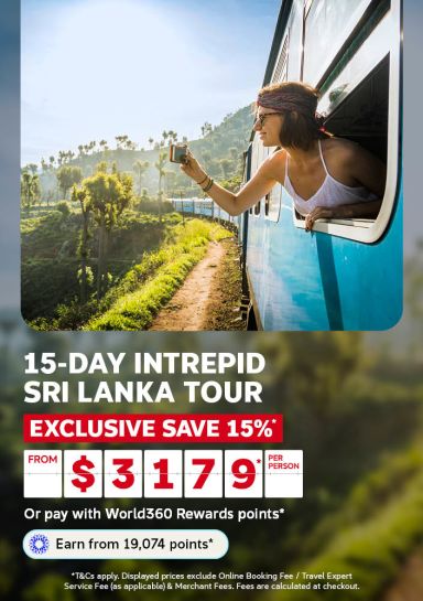 Woman leaning out a train window past lush green hills in Sri Lanka for a 15 day Intrepid Sri Lanka tour saving 15 percent from 3179 per person