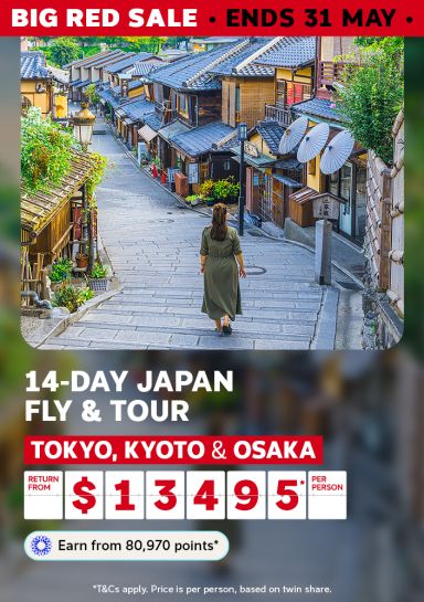 Traveller walking along a traditional cobblestone laneway lined with wooden teahouses in Kyoto for a 14-day Japan fly and tour from $13495 per person