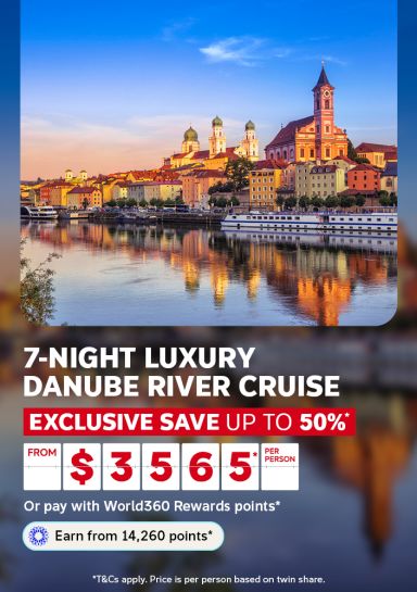 River cruise ship docked before a glowing sunset skyline for a 7-night luxury Danube River cruise saving up to 50% from $3565 per person