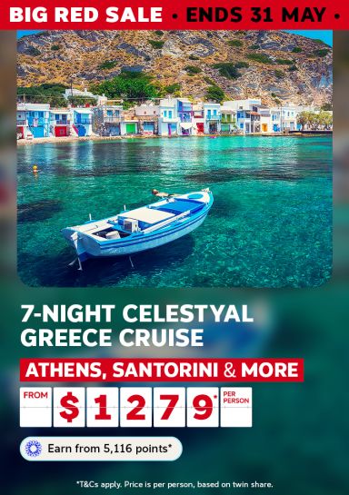 Blue boat on crystal-clear water beside a colourful Greek fishing village for a 7-night Celestyal Greece cruise from $1279 per person