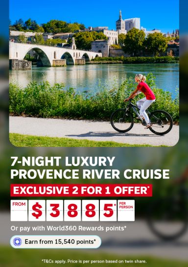 Woman cycling along the riverbank past the Avignon bridge for a 7-night luxury Provence River cruise with exclusive 2 for 1 offer from $3885 per person