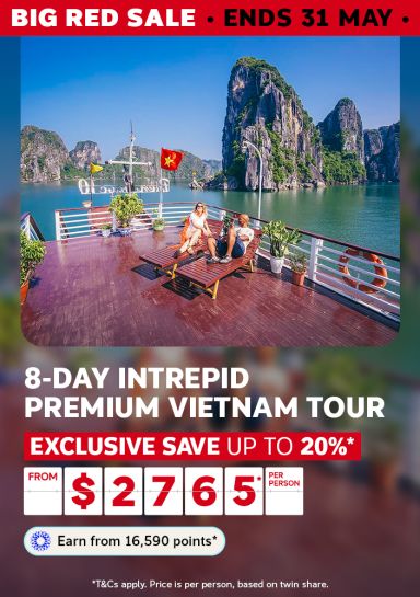 Couple relaxing on a cruise deck among Ha Long Bay limestone karsts for an 8-day Intrepid Premium Vietnam Tour saving up to 20% from $2765 per person