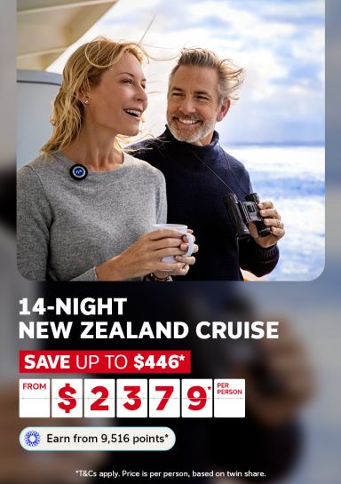 Couple enjoying coffee and binoculars on deck overlooking the ocean for a 14-night New Zealand cruise saving up to 446 dollars from 2379 per person