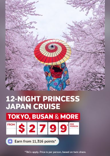 Person in a blue kimono holding a red parasol under pink cherry blossoms for a 12-night Princess Japan cruise to Tokyo, Busan and more from $2799 per person