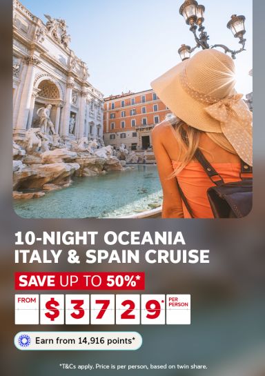Woman with a wide-brimmed hat looking at the Trevi Fountain in Rome featuring a 10-night Oceania Italy & Spain cruise from $3,729