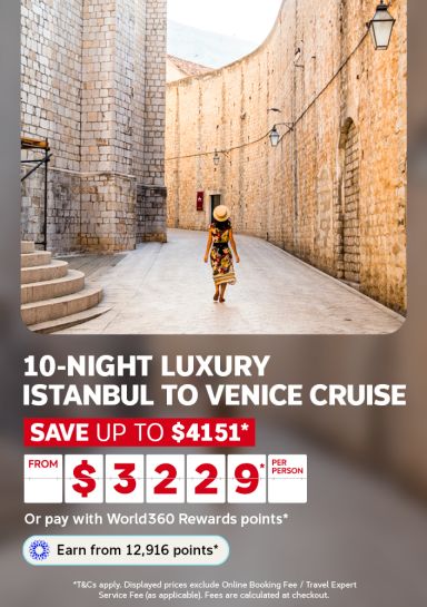 Woman in a floral dress walking along a sunlit stone lane in Dubrovnik for a 10 night luxury Istanbul to Venice cruise from $3229 per person saving up to $4151