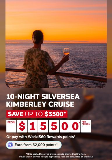 Woman raising a glass of wine at sunset over calm ocean waters for a 10 night Silversea Kimberley cruise from $15000 per person saving up to $3500