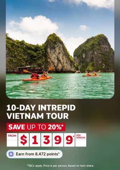 Kayakers paddling emerald waters among limestone karsts in Ha Long Bay for a 10-day Intrepid Vietnam tour saving up to 20% from $1399 per person