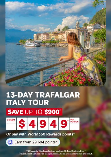 Woman in a flowing dress admiring Lake Como waterfront village for a 13-day Trafalgar Italy tour saving up to 900 from 4949 per person