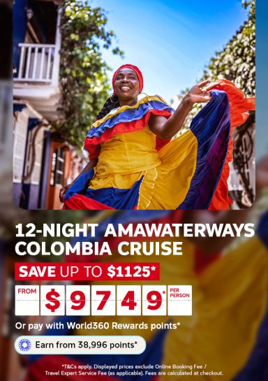 Smiling woman in a colourful dress dancing on a colonial street for a 12 night Amawaterways Colombia cruise from $9749 per person saving up to $1125