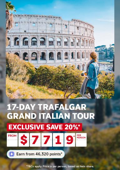 Woman with a camera admiring the ancient Roman Colosseum for a 17-day Trafalgar Grand Italian Tour saving 20% from $7719 per person