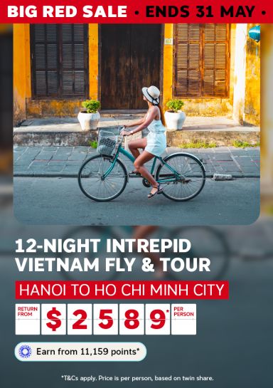 Couple among moss-covered Angkor Wat ruins for a Big Red Sale 10-night Cambodia and Vietnam cruise and tour saving up to 50% from $3745 per person