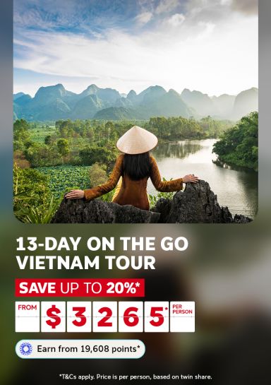 Woman in a conical hat admiring a misty river valley in Vietnam for a 13-day tour saving up to 20% from $3265 per person