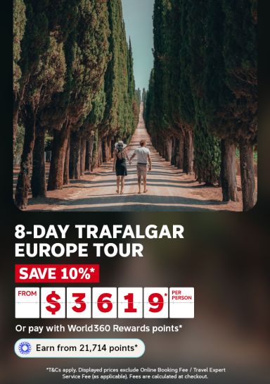 Couple holding hands on a dirt road lined with tall cypress trees in Tuscany for an 8 day Trafalgar Europe tour from $3619 per person saving 10%