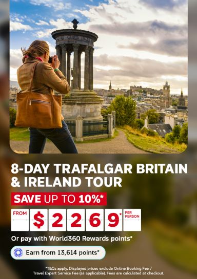 Woman photographing a monument overlooking Edinburgh rooftops for an 8-day Trafalgar Britain and Ireland tour from $2269 per person saving up to 10%