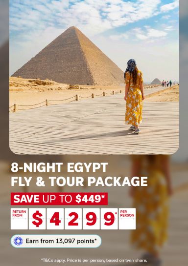 Woman in a yellow dress approaching the Great Pyramid of Giza for an 8-night Egypt fly and tour package saving up to $449 from $4299 per person