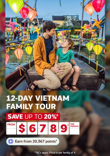 Adult and child on a boat surrounded by colourful Hoi An lanterns for a 12-day Vietnam family tour saving up to 20% from $6789 per family of 4