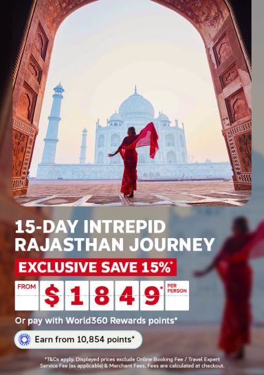 Woman in a red sari framed by an archway before the Taj Mahal for a 15 day Intrepid Rajasthan journey saving 15 percent from 1849 per person