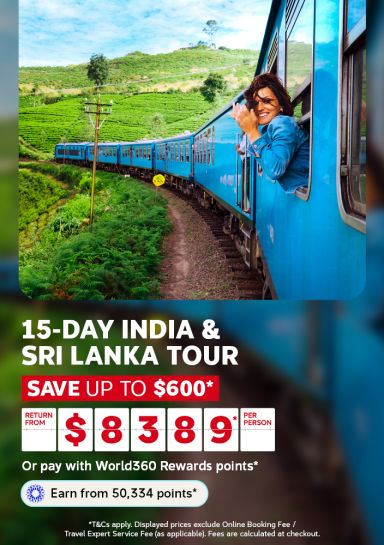Smiling woman leaning from a blue train window past tea plantations for a 15 day India and Sri Lanka tour from $8389 per person saving up to $600