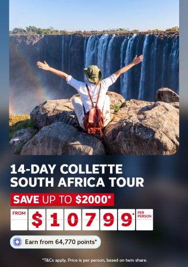 Person with arms outstretched on rocks before a vast waterfall for a 14-day Collette South Africa tour saving up to $2000 from $10799 per person