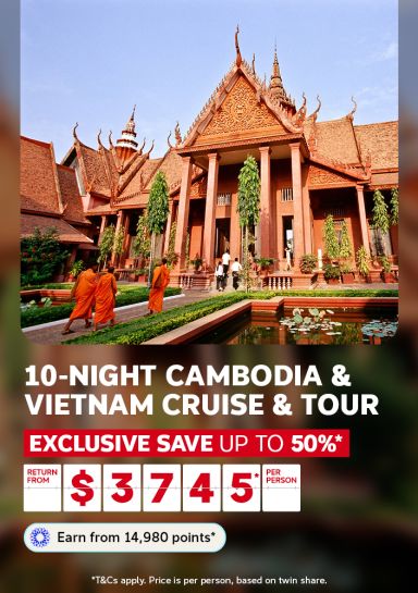 Buddhist monks walking past Cambodian temple pavilion for a 10 night Cambodia and Vietnam cruise and tour saving up to 50% from $3745 per person