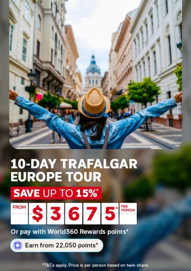 Woman with arms outstretched walking down a charming European street for a 10-day Trafalgar Europe tour saving up to 15% from $3675 per person