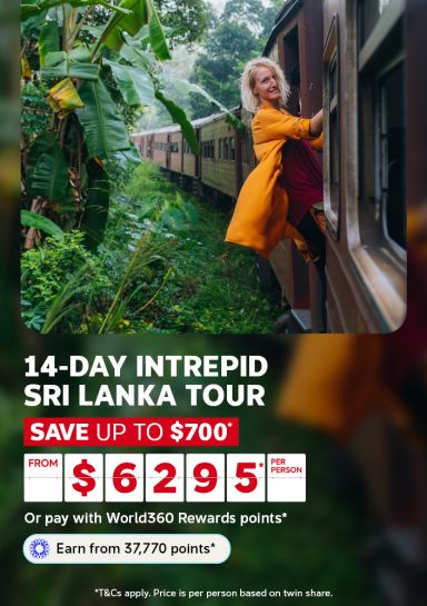 Woman leaning out of a train window through lush jungle for a 14-day Intrepid Sri Lanka tour saving up to $700 from $6295 per person