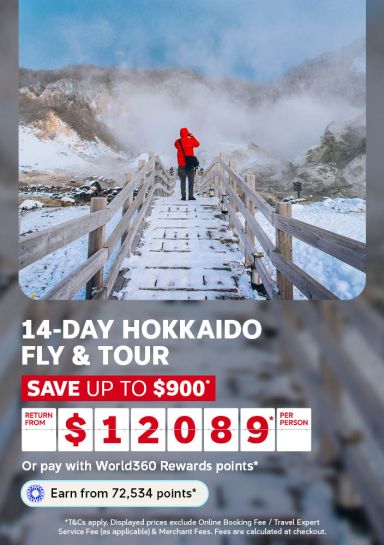 Hiker in a red jacket on a snowy boardwalk overlooking hot springs for a 14 day Hokkaido fly and tour saving up to 900 dollars from 12089 per person