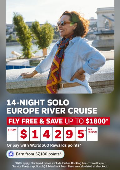 Woman smiling beside the Danube by Budapest's Chain Bridge for a 14-night solo Europe river cruise saving up to 1800 from 14295 per person