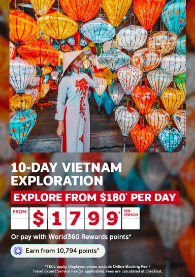 Woman in traditional dress admiring colourful lanterns in Hoi An for a 10-day Vietnam exploration from 180 per day from 1799 per person