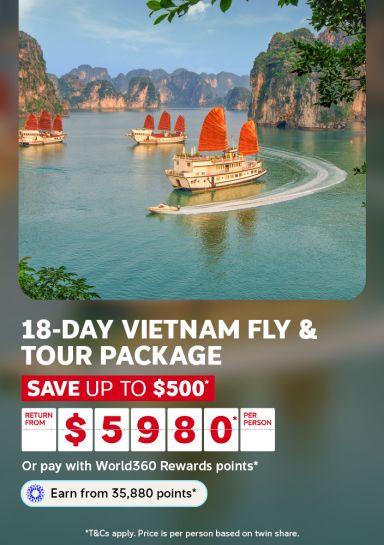 Red sailed junk boats cruising past limestone karsts in Halong Bay for an 18-day Vietnam fly and tour package saving up to $500 from $598 per person