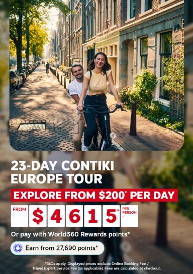 Couple laughing while riding a bicycle down a sunlit Amsterdam street for a 23-day Contiki Europe tour from 200 per day from 4615 per person