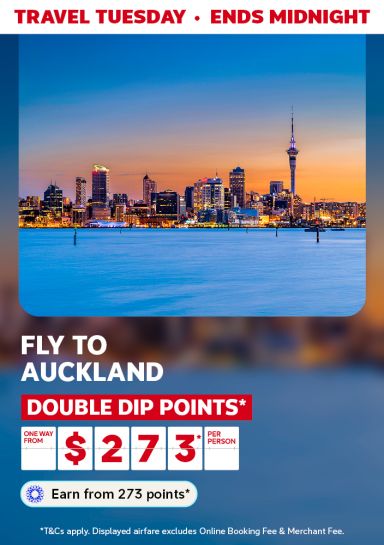 Auckland skyline and Sky Tower at dusk over the water for a Travel Tuesday flight one way from $273 per person