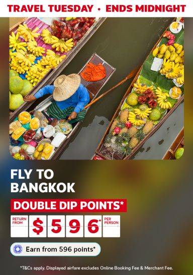 Top down view of a person with several canoes filled with fruit featuring return flights to Bangkok from $596