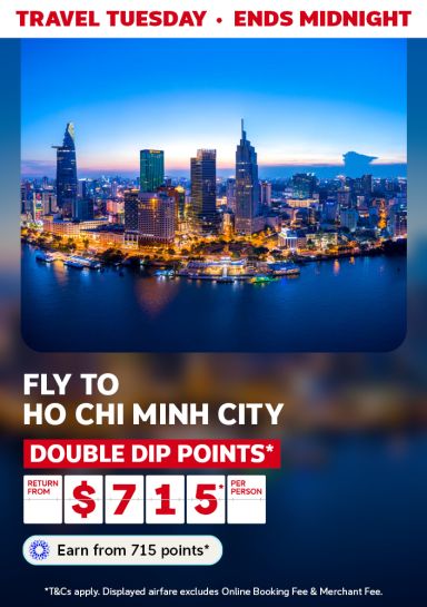Ho Chi Minh City skyline lit up at dusk along the river for a Travel Tuesday flight deal returning from $715 per person with double dip points
