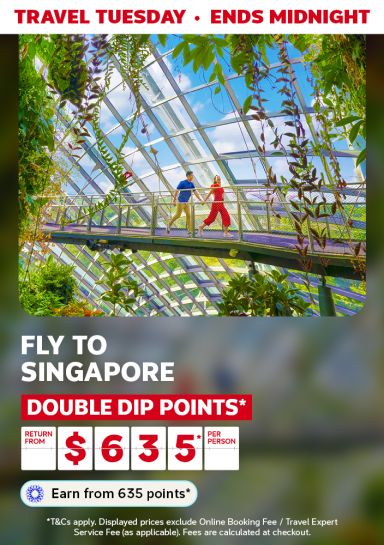 Couple walking hand in hand through Gardens by the Bay in Singapore featuring return flights to Singapore from $635