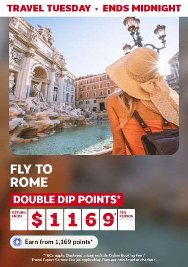Woman gazing at the Trevi Fountain featuring return flights to Rome from $1,169