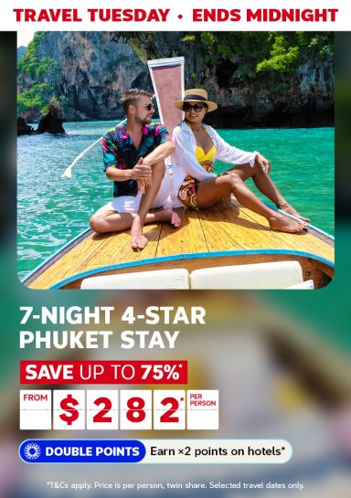 Travel Tuesday - ends midnight | 7-night, 4-star Phuket stay. Save up to 75%* - from $282* per person. Double Points - Earn 2x points on hotels* | *T&Cs apply. Price is per person, twin share. Selected travel dates only. | Couple sitting on a boat with limestone mountains in the background