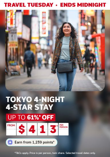 Travel Tuesday - ends midnight | Tokyo 4-night 4-stay stay. Up to 61%* off | from $413* per person - earn from 1,239 points* | *T&Cs apply. Price is per person, twin share. Selected travel dates only. | Woman walking through a neon-lit street in Japan
