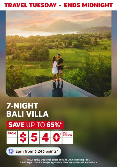 Couple standing on the edge of a reflective platform overlooking lush, green fields featuring a 7-night Bali villa from $540