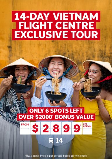 14-day Vietnam exclusive Flight Centre Tour | only 6 spots left! Over $2000* bonus value - from $2,899* per person | three people smiling eating noodles in front of a yellow wall
