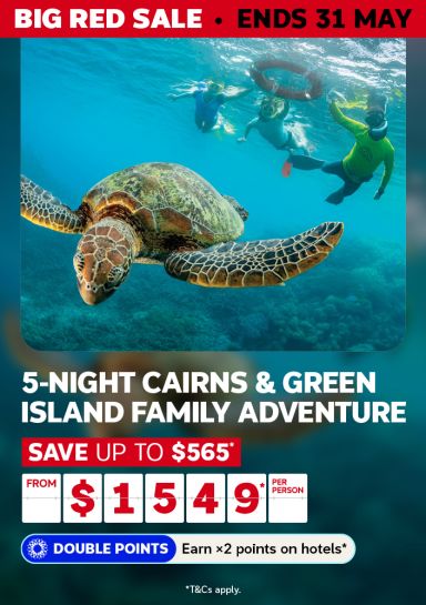 Snorkellers swimming with a sea turtle on the Great Barrier Reef for a Big Red Sale 5-night Cairns and Green Island adventure from $1549 per person