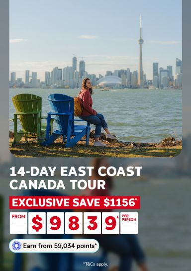 14-day East Coast Canada tour | exclusive save $1,156* from $9,839* per person | Earn from 59,034 points* | *T&Cs apply. | Woman sitting on a blue chair looking out at Ontario, Canada