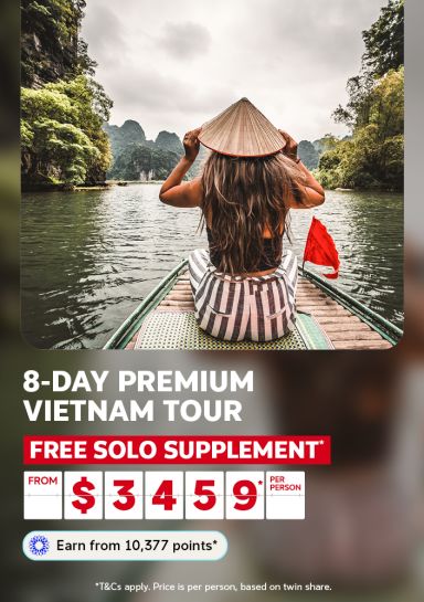 8-day premium Vietnam tour | free solo supplement* from $3,459* per person | Earn from 10,377 points* | *T&Cs apply. Price is per person, based on twin share. | Woman sitting on a bamboo boat looking at limestone islands