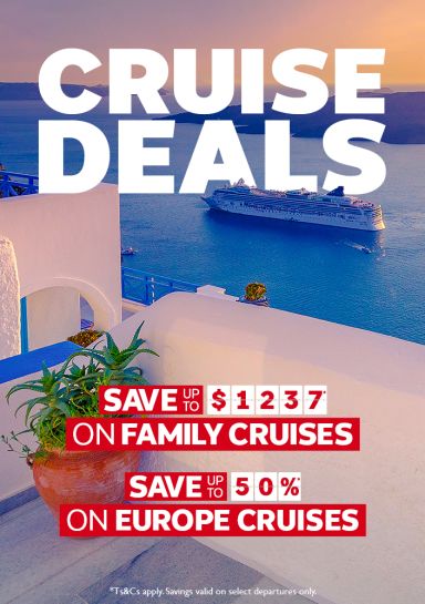 Cruise ship passing Santorini's white clifftop architecture at dusk for cruise deals saving up to $1237 on family and 50% on Europe cruises