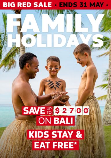 Performer sharing a coconut with face-painted children on a tropical beach for a Big Red Sale saving up to $2700 on Bali with kids stay and eat free
