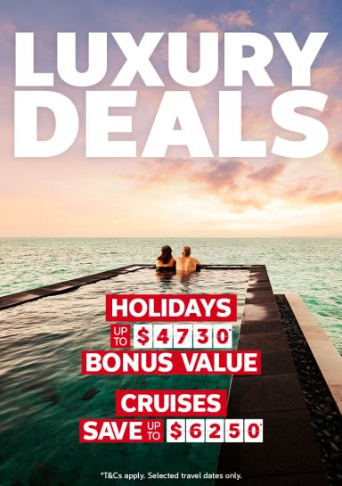 Couple relaxing in an infinity pool overlooking a calm ocean at sunset for luxury deals with holidays up to $4730 bonus value and cruises saving up to $6250