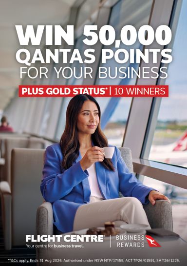 Woman drinking tea in an airport terminal featuring a chance to win 50,000 Qantas points for your business plus gold status for 10 winners